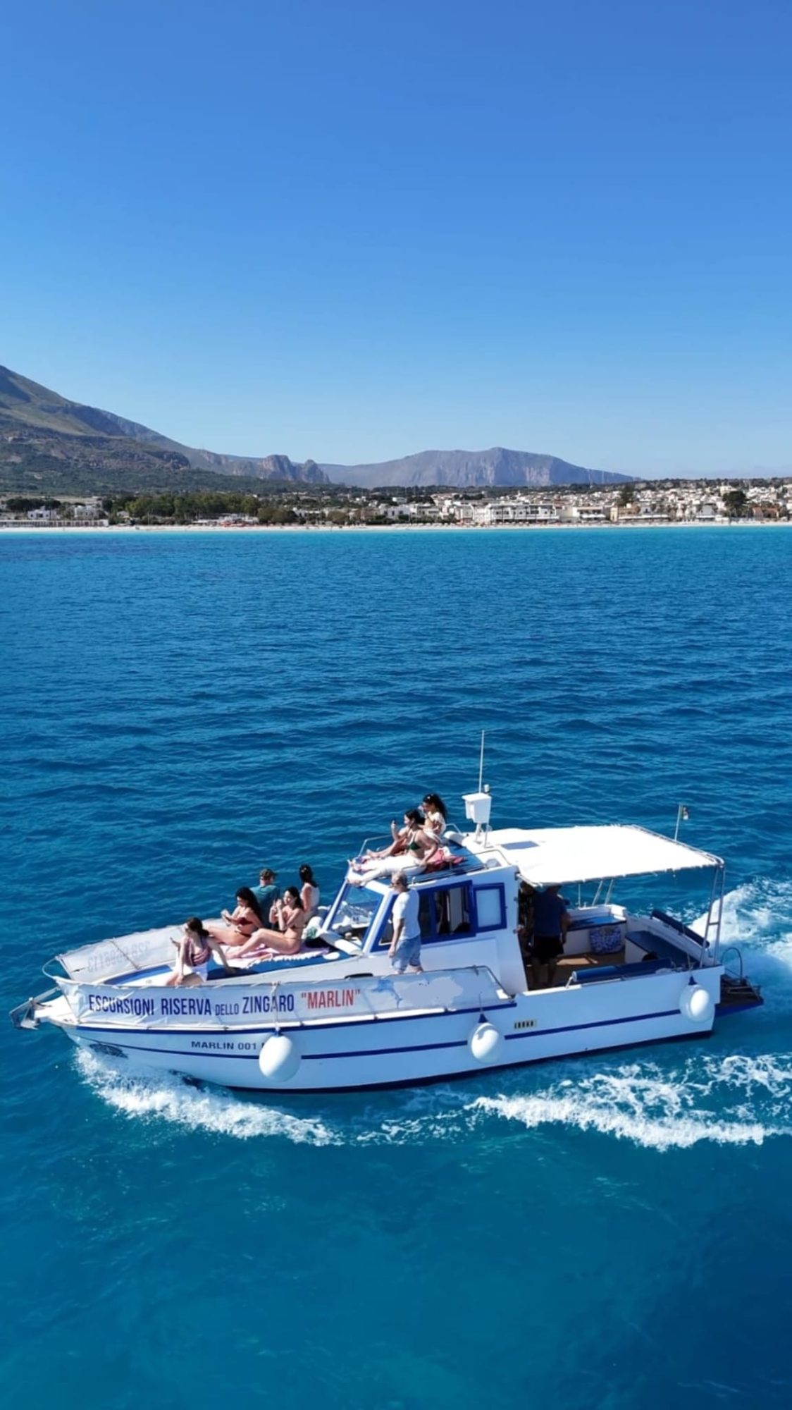 La barca Marlin naviga sul mare turchese davanti a San Vito Lo Capo